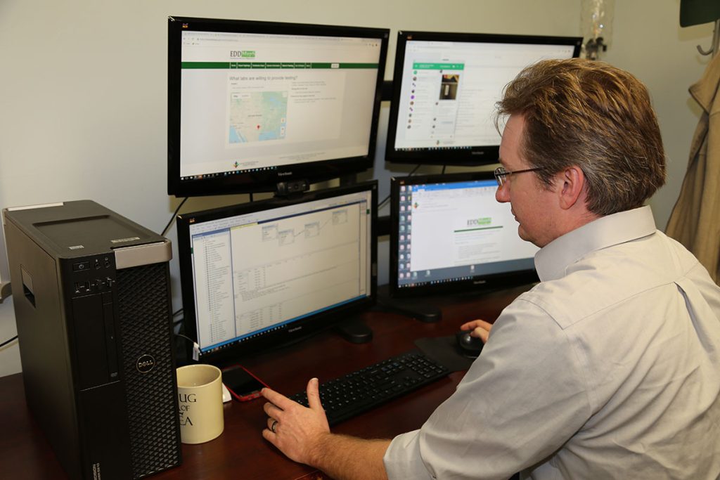 Person sitting at desk with 4 screens provide service support to users.
