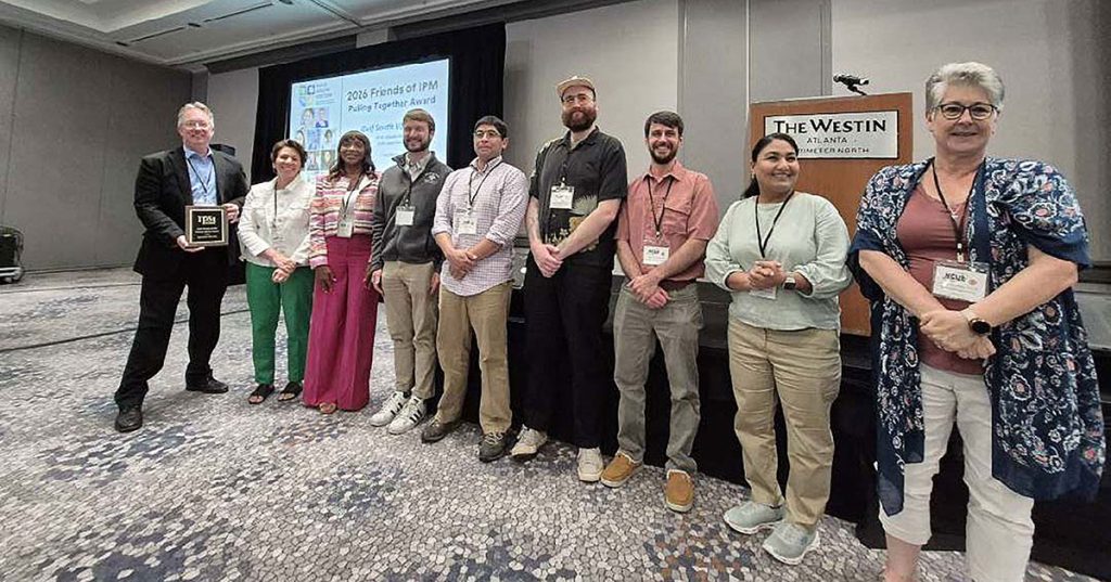 Gulf South VECTOR partners receive "Pulling Together" award from Southern IPM Center Co-Director, Joe LaForest at the 2026 NCUE.